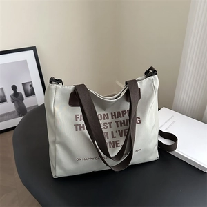 Minimalist beige canvas tote bag with brown straps and vintage slogan print for women