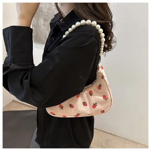 Corduroy shoulder bag with red strawberry print and large faux pearl strap detail
