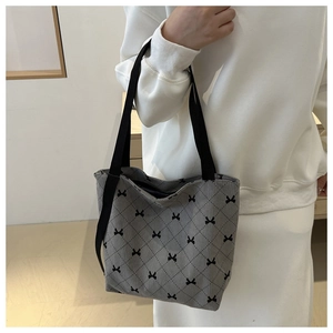 Détail du sac fourre-tout gris en velours côtelé avec motifs de nœuds noirs et anses