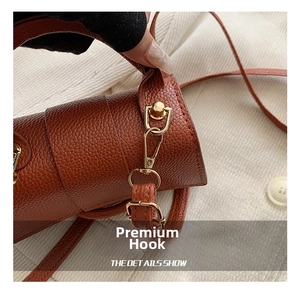 Detail of premium golden metal hook and swivel clasp on brown lychee grain leather bag