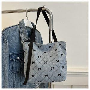 Détail du sac cabas en velours côtelé bleu clair avec motifs de nœuds et losanges