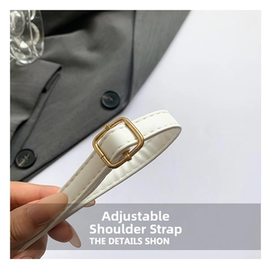 Close-up of adjustable white leather strap with polished gold-tone metal buckle