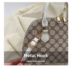 Detailed close-up of premium gold hardware hooks and white leather trim on shell bag