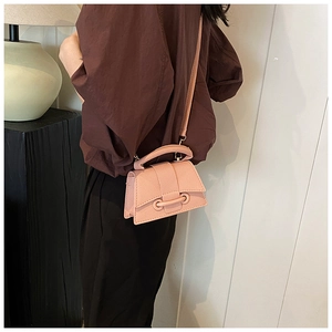 Detailed side view of mini dusty pink crossbody bag with pebbled leather and U-ring buckle