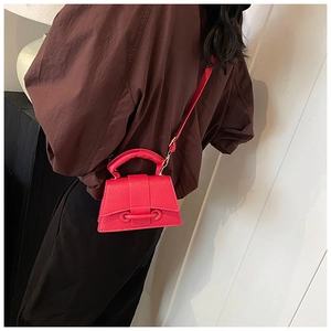 Detailed back view of a magenta crossbody mini bag with lychee grain leather on a model