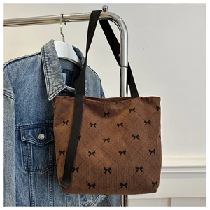 Détail du sac cabas en velours côtelé marron avec imprimés nœuds et bandoulière