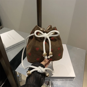 Brown corduroy bucket bag with strawberry embroidery and white drawstring closure