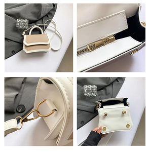 Detail view of mini contrasting handbag showing golden zipper and leather texture