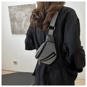 Detail of black crossbody bag with silver rhinestones and chevron woven wide strap