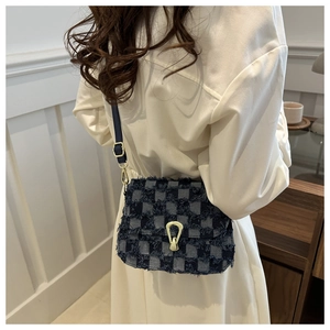 Gros plan du sac en jean à damier avec bords effilochés et boucle métallique dorée