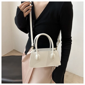 Detail of white mini tote bag with lychee grain texture and elegant handles on a model