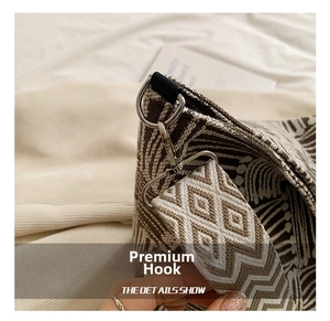 Close-up of silver metal hook and geometric jacquard woven strap on a tote bag
