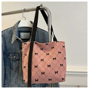 Détail du cabas en velours côtelé rose avec imprimé nœud noir et motif à losanges