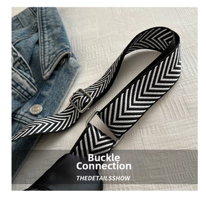 Detail of adjustable black and white herringbone woven strap with silver buckle hardware