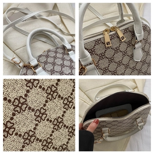 Detail view of the quilted leather fabric, gold hardware and interior capacity of the bag