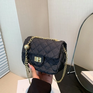 Minimalistische schwarze Stepptasche aus Denim mit Goldkette und Kugelanhänger
