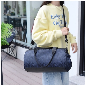 Blue camo duffel bag detail showing side drawstring pocket and adjustable shoulder strap