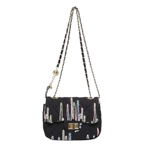 Black quilted crossbody bag with colorful vertical stripes and golden chain strap