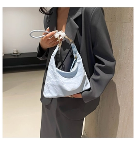 Detail of light blue hobo bag with white beaded handle and CLASSIC logo print