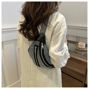 Detail of trendy rhinestone crossbody bag featuring black and white striped shoulder strap