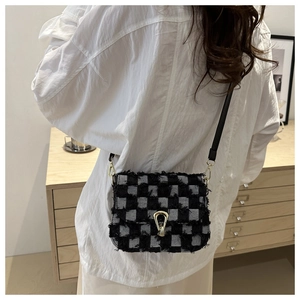 Détail du sac bandoulière en tweed avec fermoir doré et motif pied-de-poule chic