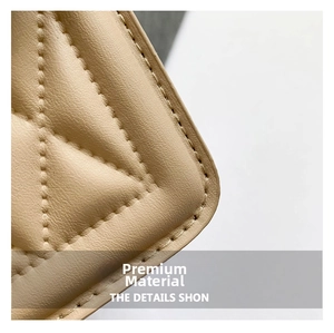 Detail view of beige quilted faux leather fabric with neat stitching on a chain bag