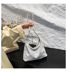 Detail of silver crinkle hobo bag with marble decorative beads on the shoulder strap