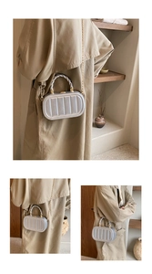 Close-up of silver vertical stripe mini box bag with textured handle and chain