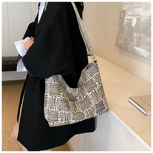 Detail of large beige and brown striped tote bag with textured woven fabric texture