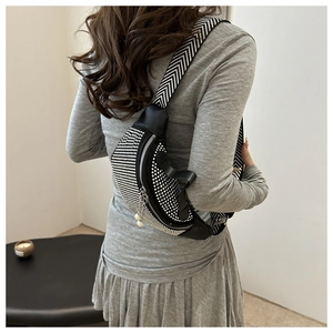 Détail du sac banane en cuir noir avec strass argentés et pendentif de fermeture en perle
