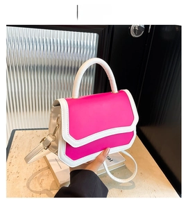 Detail of rose red and white contrast faux leather crossbody bag with gold hardware
