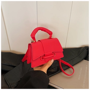 Close-up of fuchsia lychee pattern leather mini handbag with gold buckle and top handle