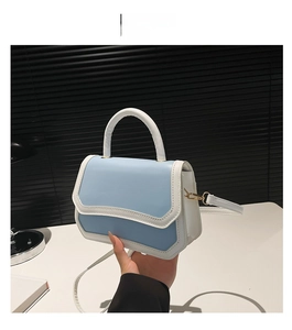 Detail view of the blue and white crossbody bag with golden metal buckle and PU texture