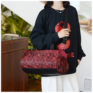 Detail of red camouflage duffel bag with side drawstring pocket and adjustable shoulder strap