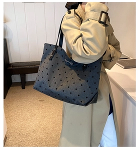 Detailed shot of grey tote bag featuring black polka dots and embroidered bows decoration