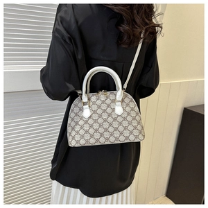 Lifestyle shot of woman wearing beige shell-shaped crossbody bag with vintage patterns
