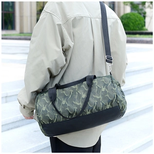 Detail of camouflage travel bag with adjustable strap worn by a model on stairs