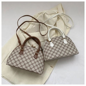 Detail of shell-shaped handbags featuring clover geometric patterns and golden zippers