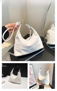 Detail of white pleated hobo bag featuring large bead accents and gold metal carabiners