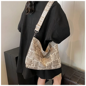 Detail of large canvas tote bag showing brown geometric pattern and wide jacquard strap
