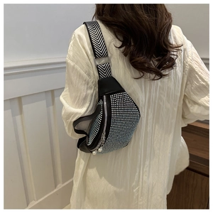 Detail of black crescent crossbody bag with silver rhinestones and woven shoulder strap