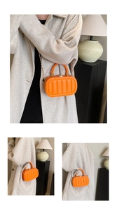 Detail of bright orange textured mini bag with vertical pleats and golden chain strap