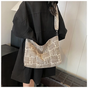 Detail of large canvas tote bag with brown geometric pattern and wide shoulder strap