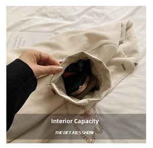 Interior view showing capacity of cream canvas bucket bag with gold chain strap