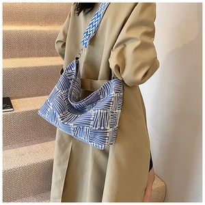 Detail of blue and white woven geometric pattern tote bag with wide wavy shoulder strap