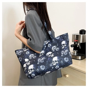 Detailed view of skull and floral print on large capacity canvas tote bag worn by model