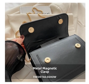 Detail of black leather crossbody bag featuring gold metal magnetic closures and inner pocket