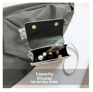 Detail view of white woven crossbody bag interior with dual magnetic gold buckles