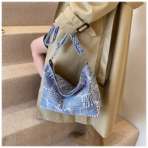 Close-up of blue and white geometric knit texture on a stylish crossbody bag