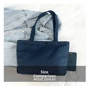 Detailed comparison showing the size of the large dark blue denim tote bag with a smartphone